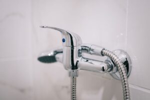 A detailed view of a sleek chrome shower faucet in a clean bathroom setting.