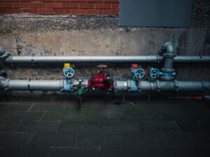 A detailed view of industrial pipes with colorful valves on a textured wall.