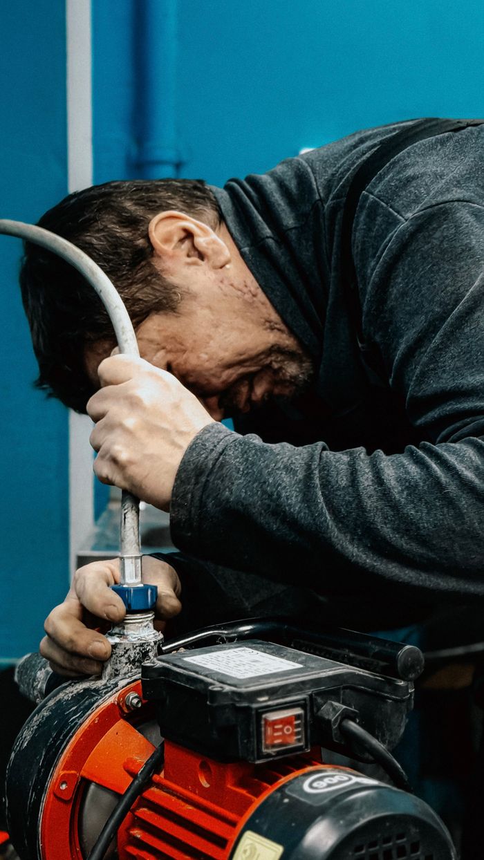 Crafting Captivating Headlines: Your awesome post title goes here A technician concentrates on adjusting a water pump indoors.
